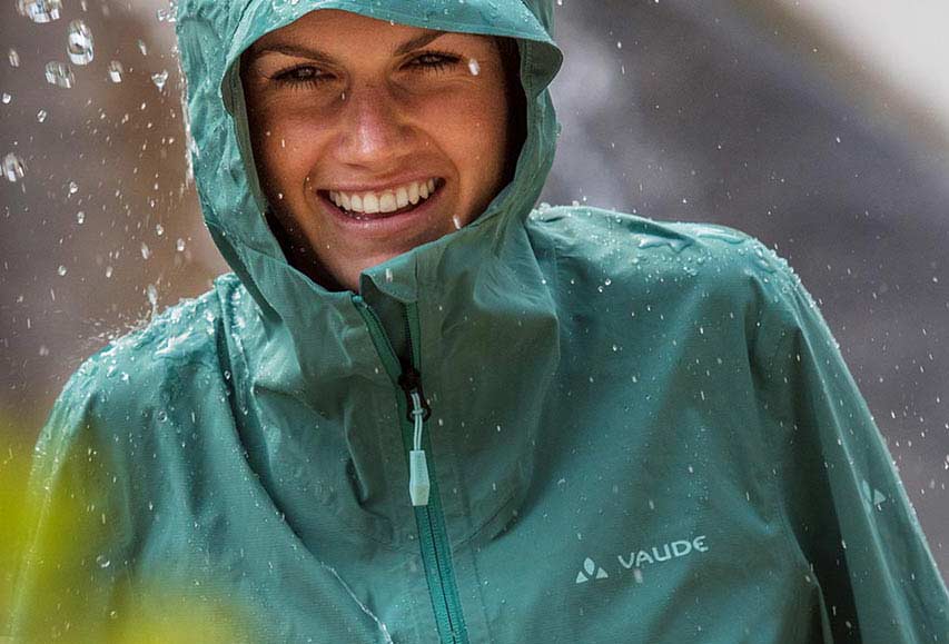 Frau mit gr&uuml;ner Regenjacke von VAUDE im Regen
