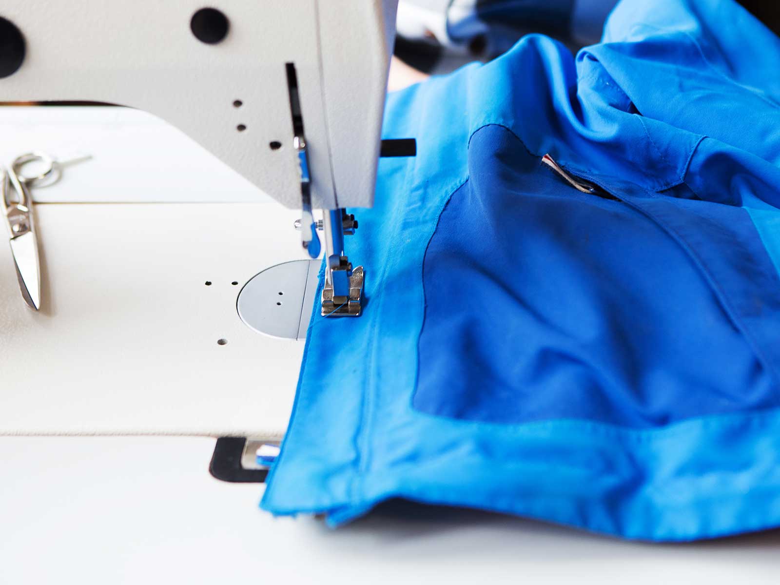 Reparieren lassen Jacke liegt unter Nähmaschine