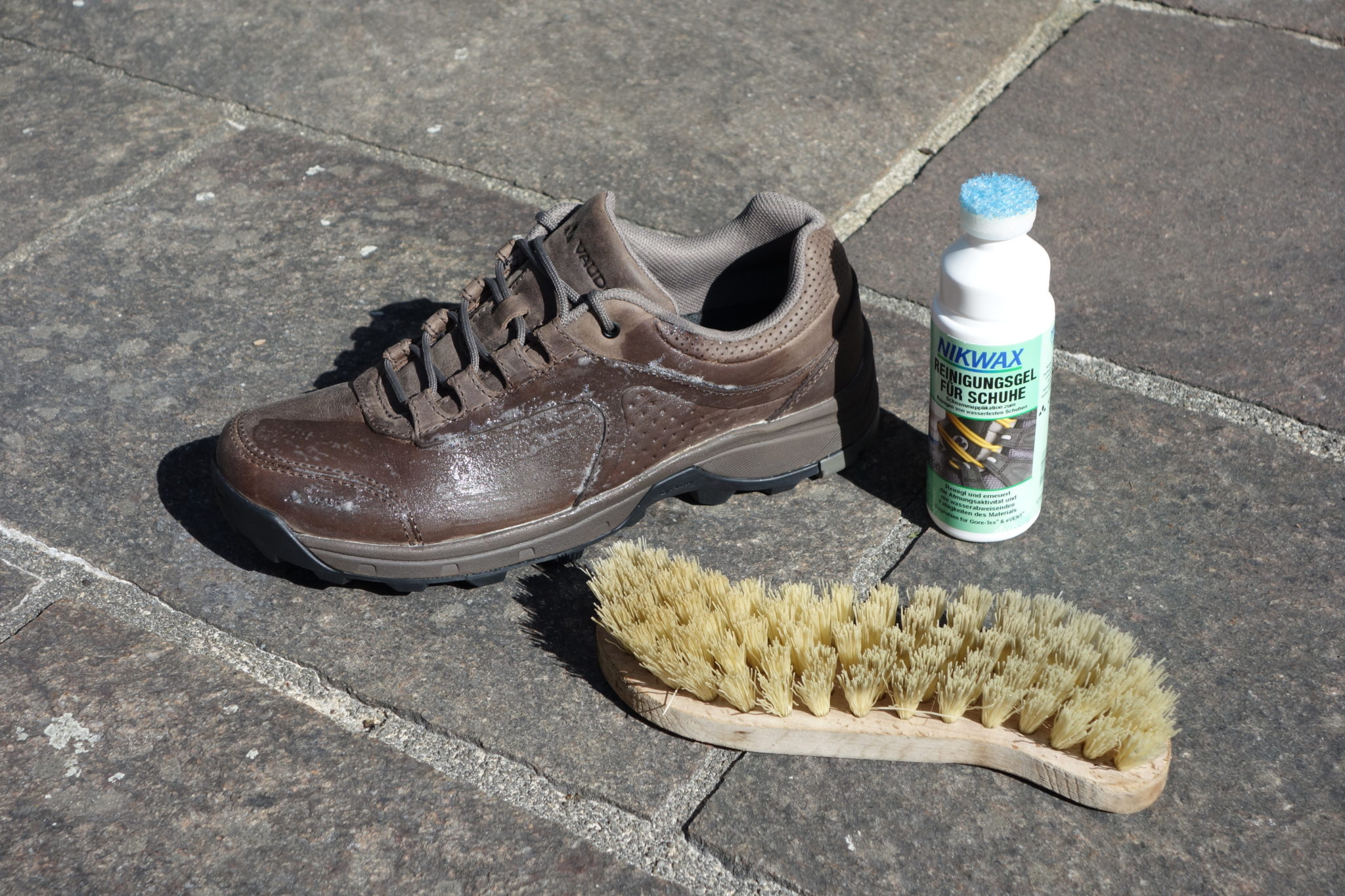 Ein Lederschuh, ein Nikwax-Reinigungsgel und eine B&uuml;rste