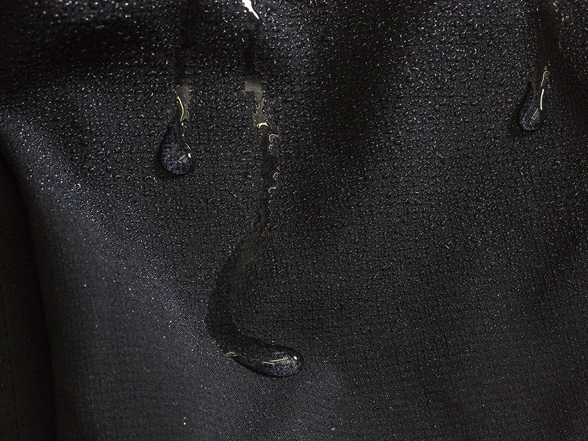 Wasser perlt von dem Jackenstoff ab