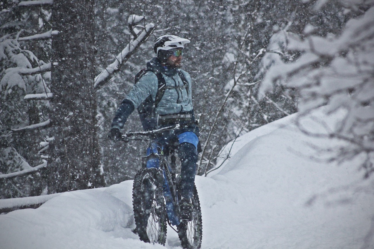 Ein Mountainbiker in einem verschneiten Wald