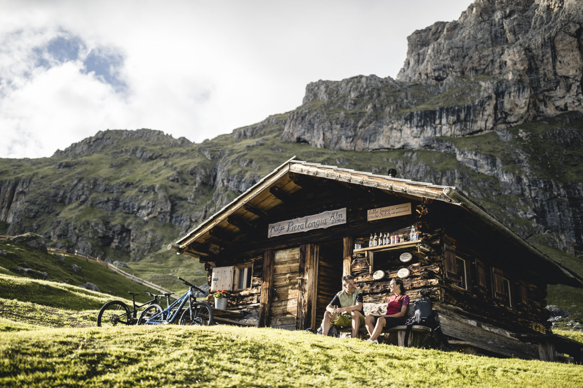 Mountainbiker sitzen vor einer Almh&uuml;tte in den Dolomiten